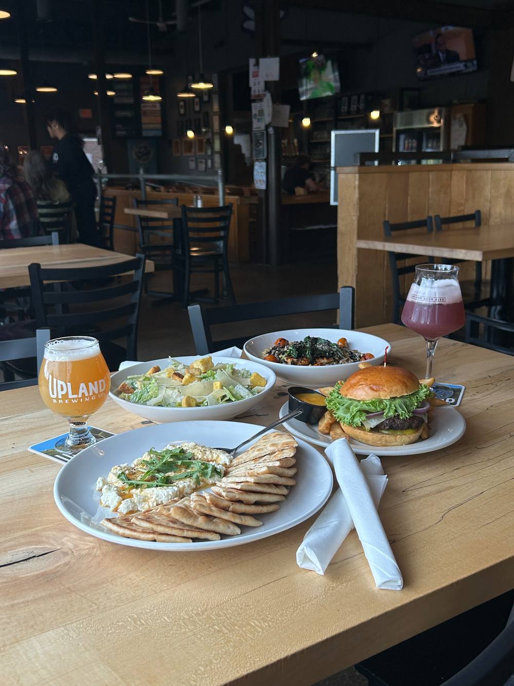 A table spread of Upland food and beer at the Bloomington Brewpub